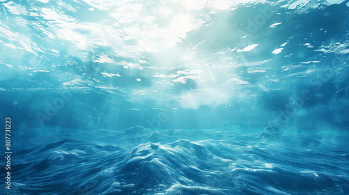Underwater view of ocean with sunlight filtering down through the surface, highlighting waves. © Natalia