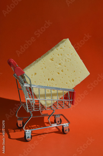 The cheese is in the shopping cart. selling food in the store. background for the design. dairy product