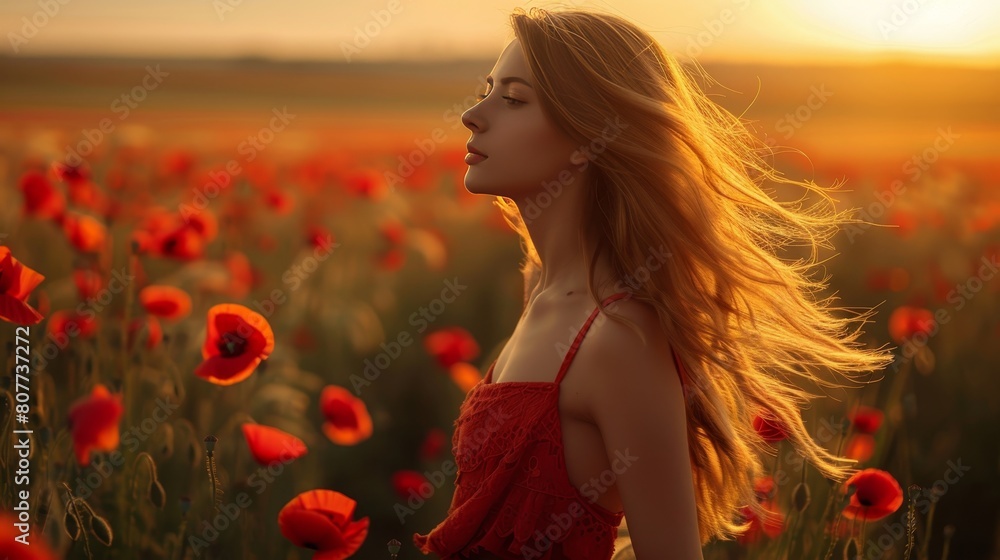 Naklejka premium Elegant woman in red dress posing in vibrant poppy field at sunset, creating stunning portrait