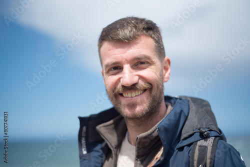 Hombre sonriendo junto al mar en invierno
