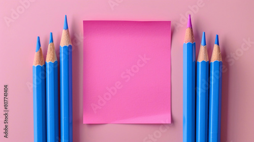Back to school concept. A pink color post it paper, pink and blue pencils on pastel pink background with copyspace.