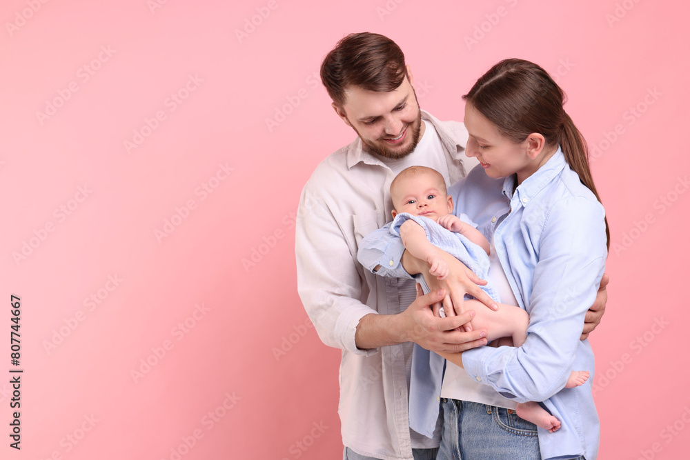 Happy family. Parents with their cute baby on pink background, space for text Happy family. Parents with their cute baby on pink background, space for text