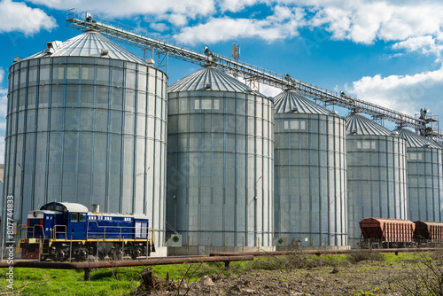 Agricultural silos for storage harvest at an agricultural production farm. Modern granary elevator. Loading and transportation of agricultural products by railway. Agribusiness