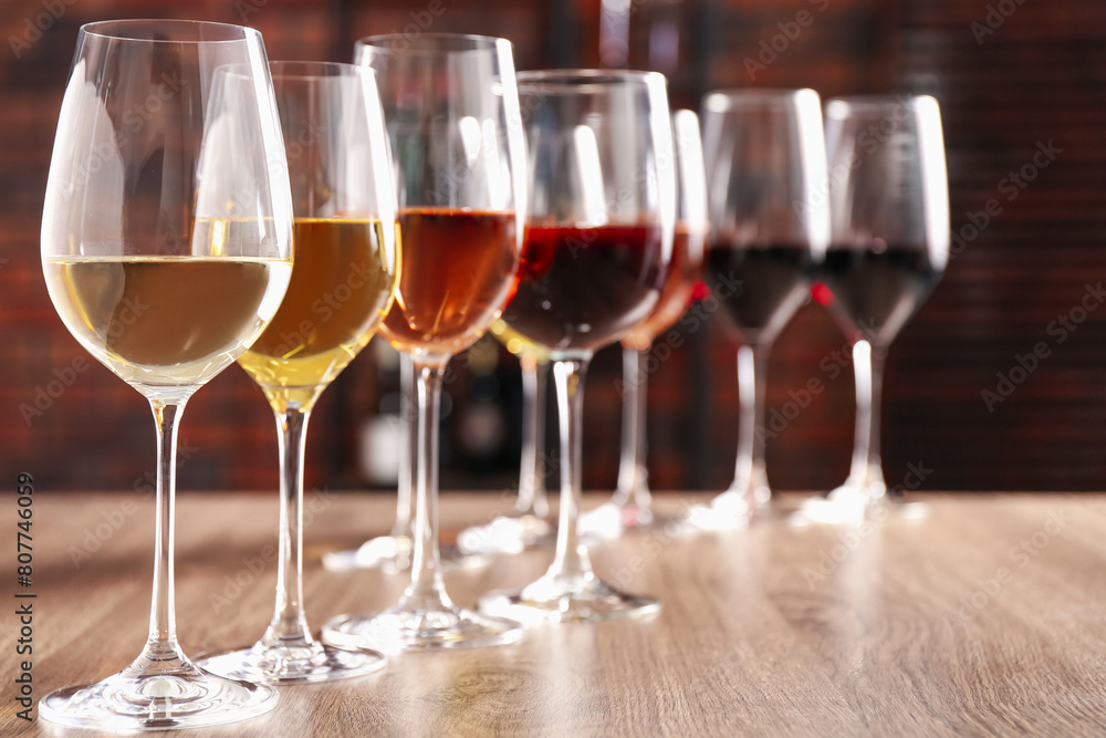Different tasty wines in glasses on wooden table, space for text Different tasty wines in glasses on wooden table, space for text