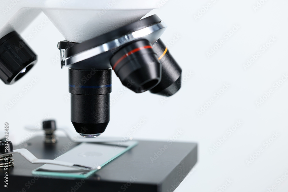 Modern microscope on light background, closeup view Modern microscope on light background, closeup view