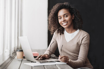 Smiling business woman working on laptop at office, Young beautiful student girl using laptop computer at cafe, Business, work from home, freelance, distance education concept