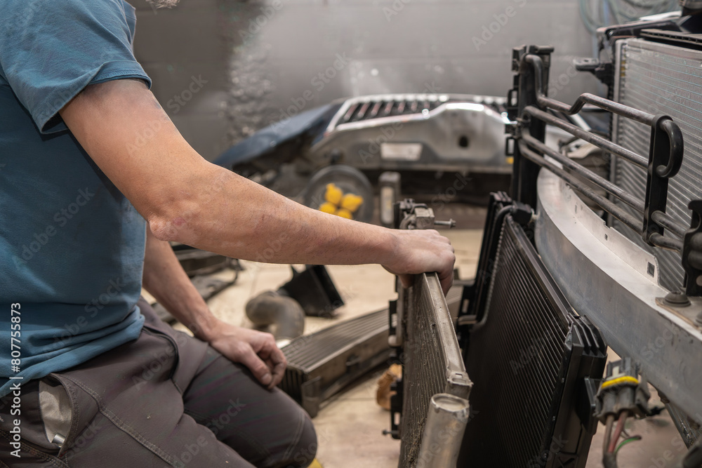 A man is working on a car radiator A man is working on a car radiator