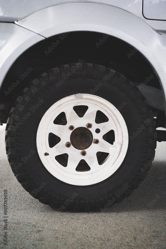 Front view of an off-road vehicle wheel with a white alloy rim. Close up view.