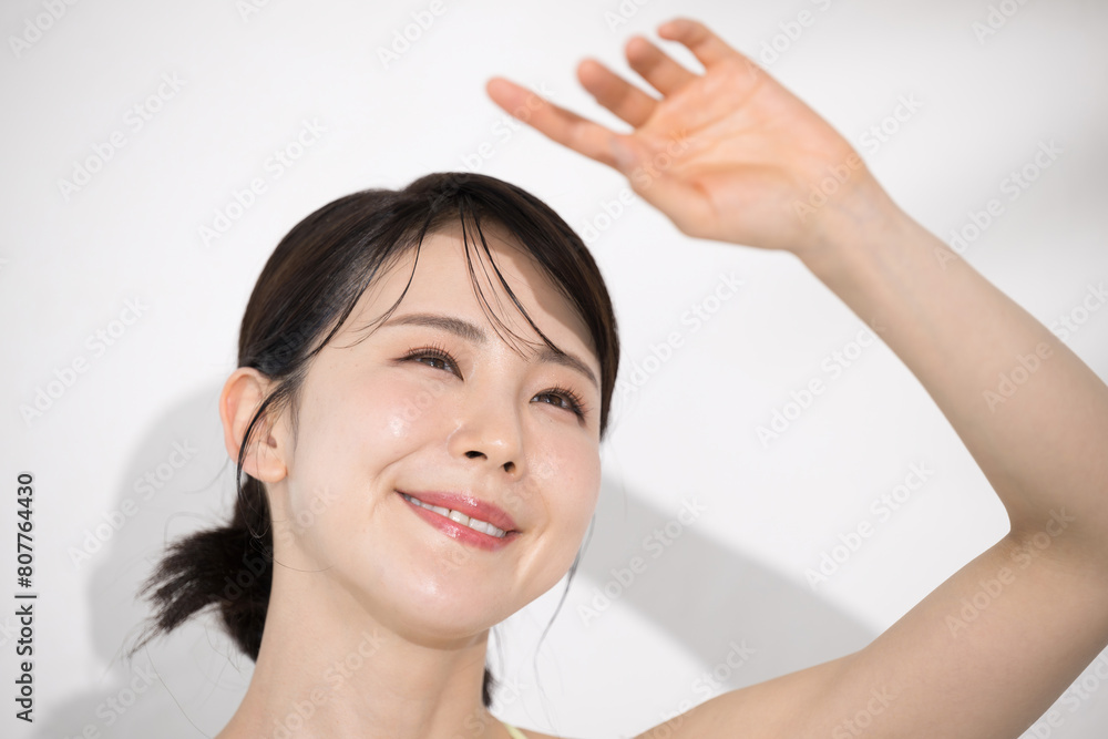 夏の美容イメージ　太陽の紫外線を気にする若い女性　焼かない夏美白やホワイトニングのイメージにも