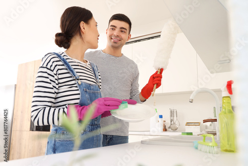 Happy young couple washing ...