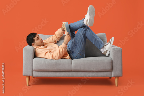 Handsome young man reading ...