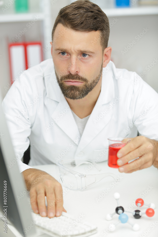 male scientist sitting at table in laboratory male scientist sitting at table in laboratory