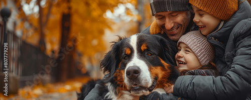 A heartwarming scene of a family cuddling a fluffy Bernese Mountain Dog on the left side of the banner, with copyspace on the right to promote the joys of pet adoption for families. photo