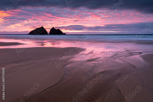Sunset over Holywell Bay, beach at low tide with sea stacks reflected in water. Near Newquay, Cornwall, England, UK. January 2019.  photo