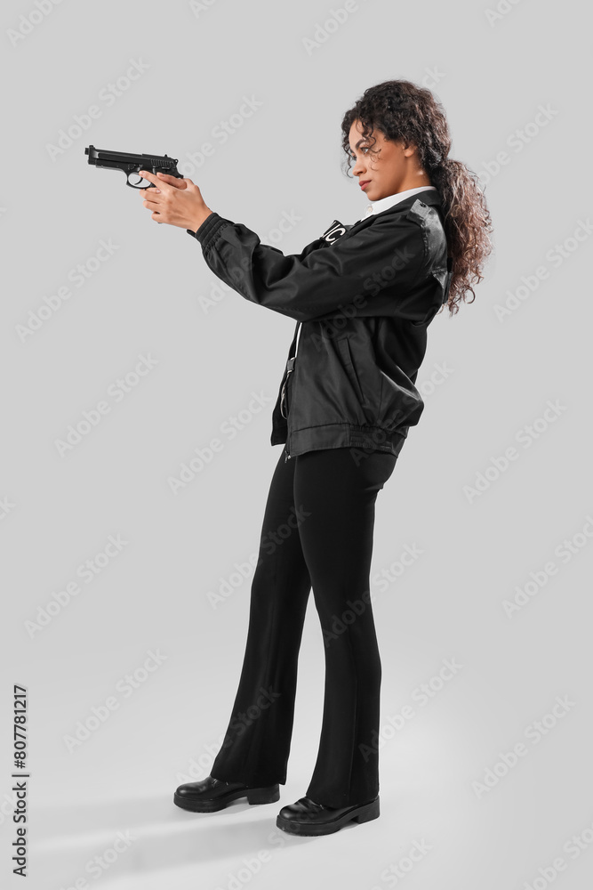 African-American female police officer with gun on white background African-American female police officer with gun on white background