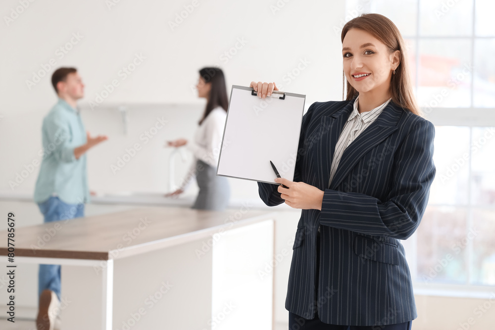 Female real estate agent with clipboard in kitchen Female real estate agent with clipboard in kitchen