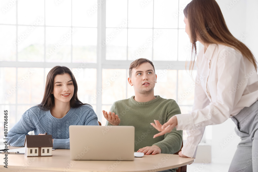 Real estate agent working with couple at table in office Real estate agent working with couple at table in office