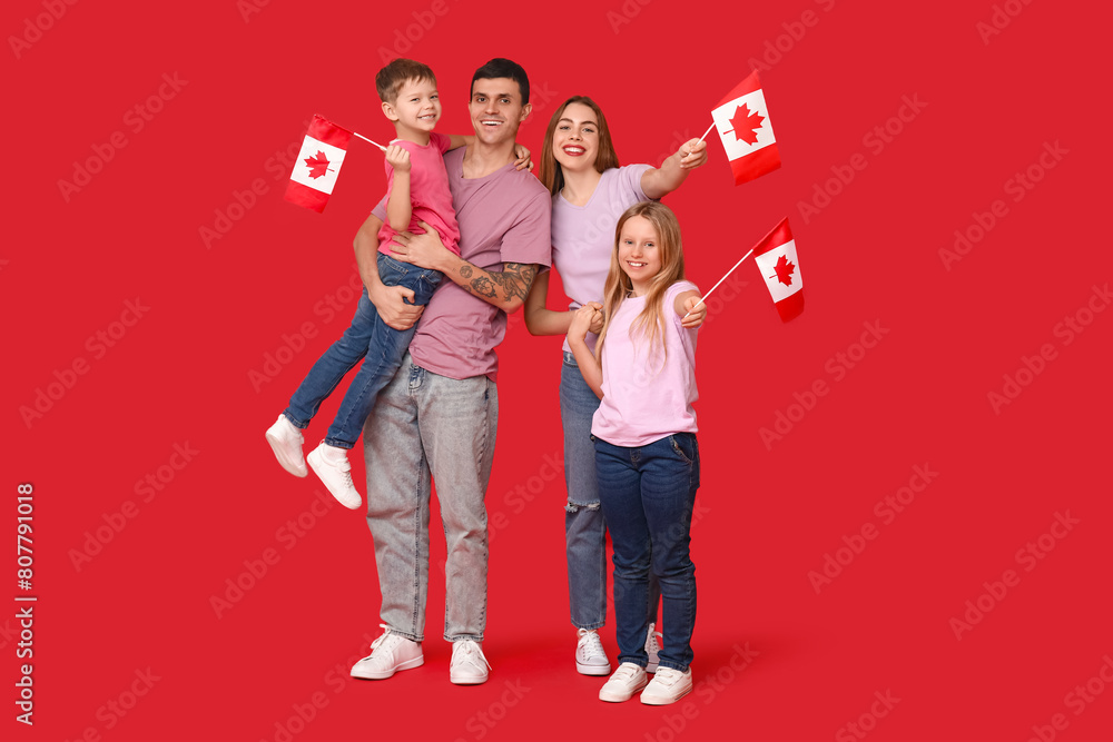 Happy family with flags of Canada on red background Happy family with flags of Canada on red background