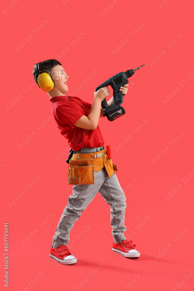 Cute little builder with drill on red background Cute little builder with drill on red background
