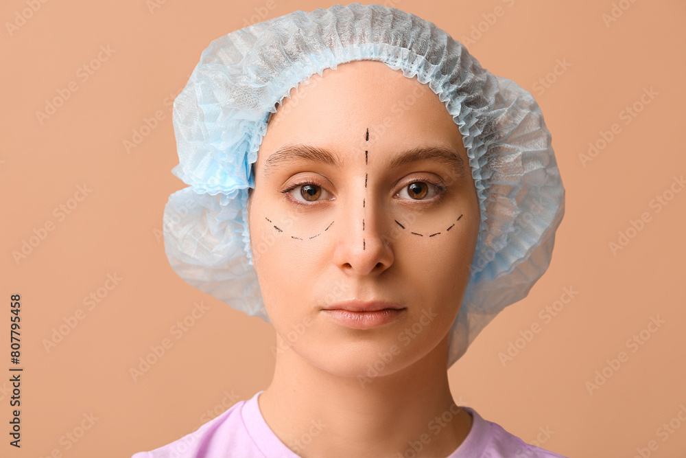 Young woman with marks on her face against brown background. Blepharoplasty concept Young woman with marks on her face against brown background. Blepharoplasty concept