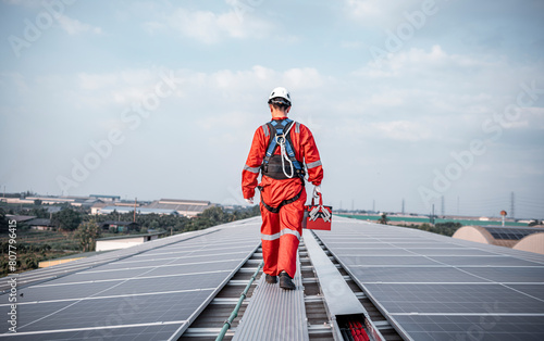 Engineers walking and holding box on factory roof inspection survey and check solar cell panel .Solar cell is smart grid sustainable ecology energy sunlight alternative power factory concept.