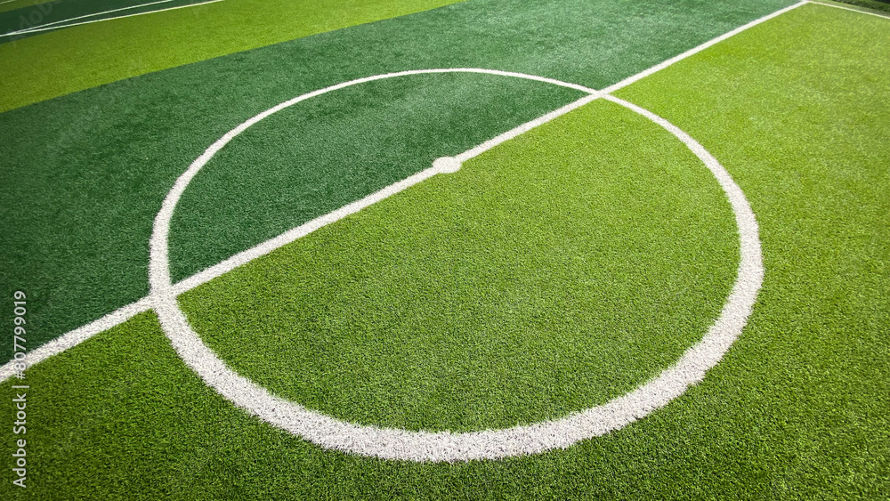 Picture of artificial grass football field Saw green artificial turf with alternating patterns. Centre Circle lines and center points Suitable for use as a wallpaper about soccer.
