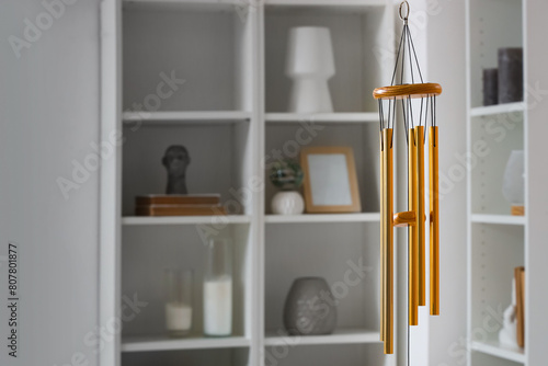 Quadro su tela Golden wind chime hanging in light bedroom, closeup