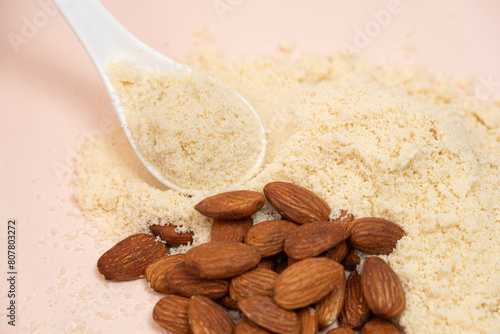 Almond flour and almonds on a beige background