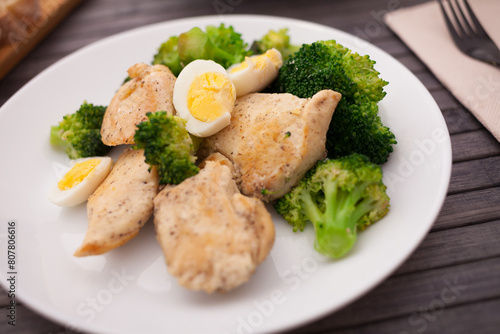 Healthy appetizer of chicken pieces with broccoli and quail eggs in bowl for healthy lunch