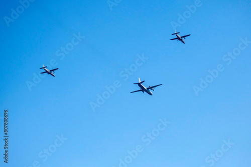 Propeller airplane are flying as a v formation on isolated blue sky