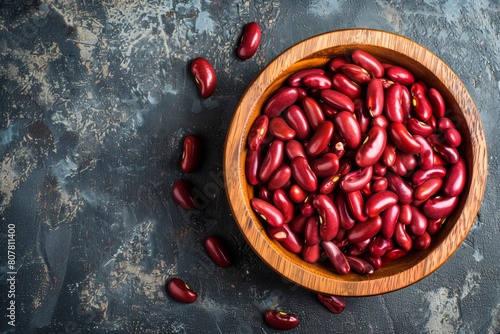 Red kidney beans in a wooden bowl. Textured surface. Copy space photo