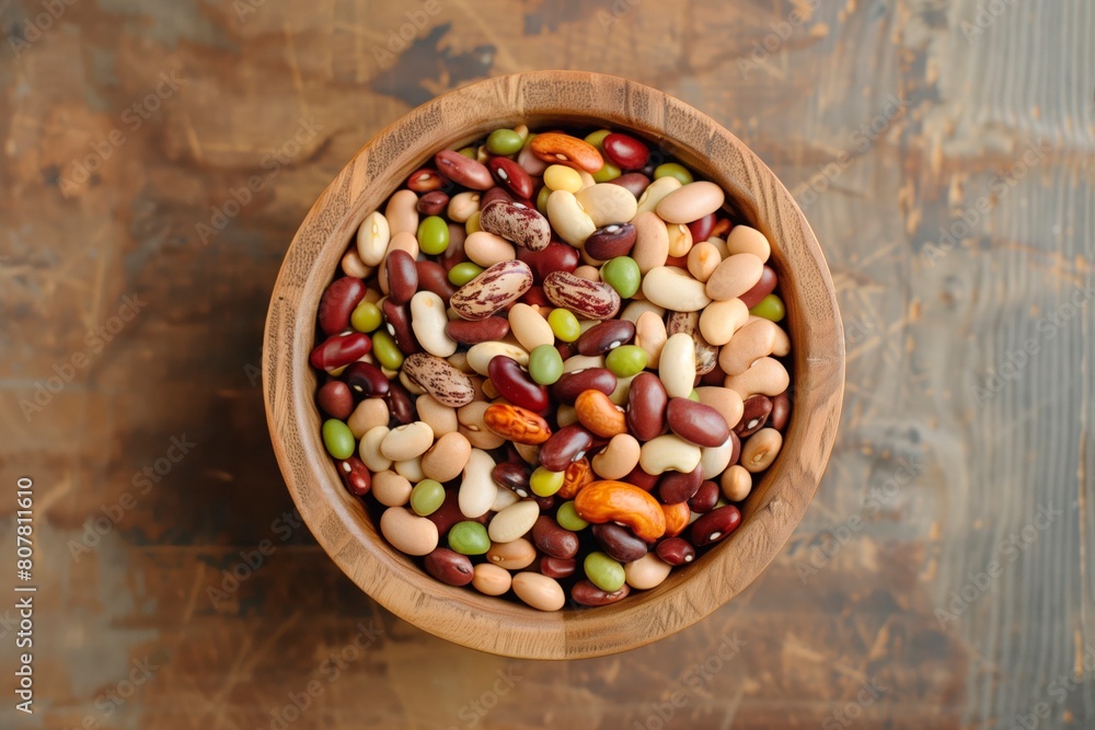 Mixed beans in a wooden bowl. Textured surface. Mixed beans in a wooden bowl. Textured surface.