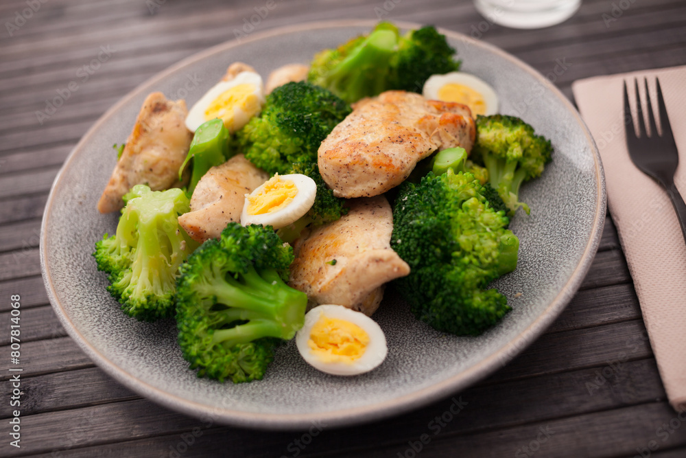 Chicken breast with broccoli and quail eggs on plate for healthy dinner Chicken breast with broccoli and quail eggs on plate for healthy dinner