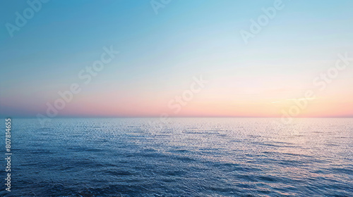 Serene ocean at dusk with clear sky and soft hues