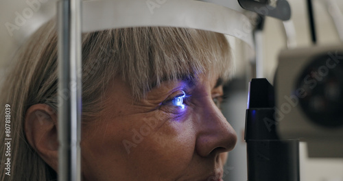 Patient, slit lamp or ophthalmology as eye test, medicine or optometry as healthcare technology. Mature woman, eyeball or light in glaucoma, exam or consultation to diagnose lens, cornea or myopia