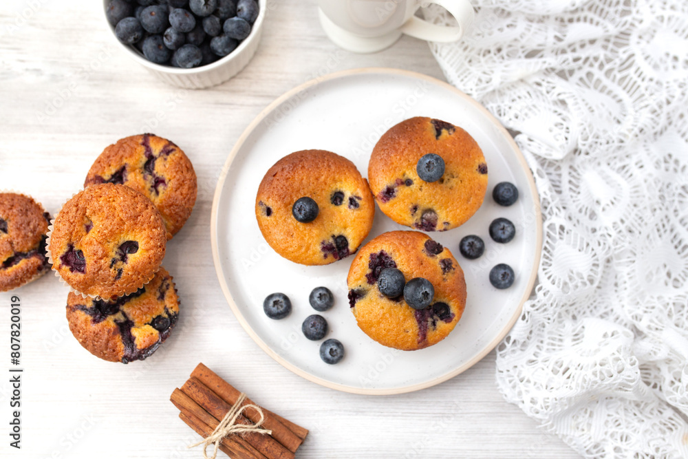 Blueberry muffins baked with fresh blueberries on a white white background, close-up. Blueberry muffins baked with fresh blueberries on a white white background, close-up.