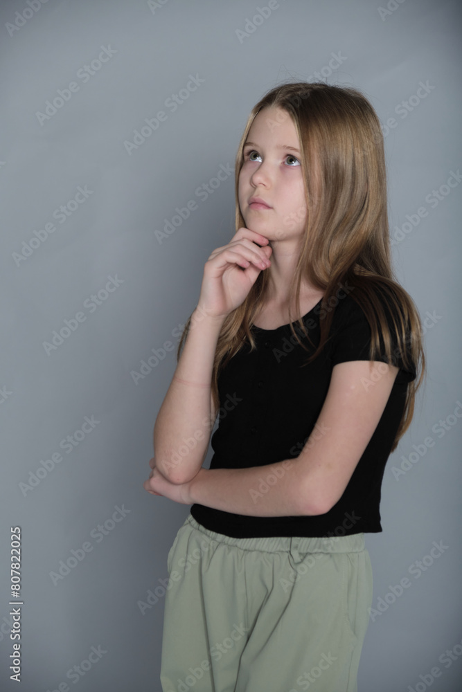 A contemplative young girl touches her chin, deep in thought. It's a moment capturing the introspective side of youth. A contemplative young girl touches her chin, deep in thought. It's a moment capturing the introspective side of youth.