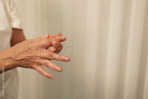 A woman uses her other hand to feel pain. and tingling along with symptoms of numbness in the hands Elderly woman tries to massage herself to relieve wrist pain