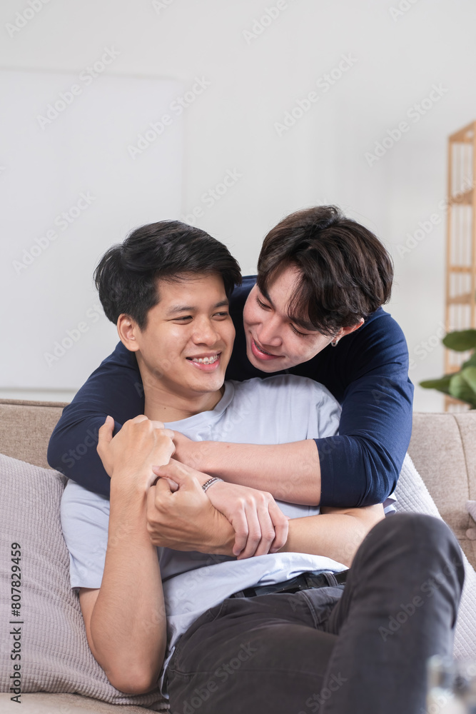 Happy Asian homosexual couple embrace on sofa in living room Happy Asian homosexual couple embrace on sofa in living room