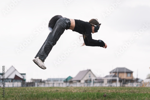 Teenage girl with cat mask and gloves doing Quadrobics. girl in a cat mask Jumps like a cat