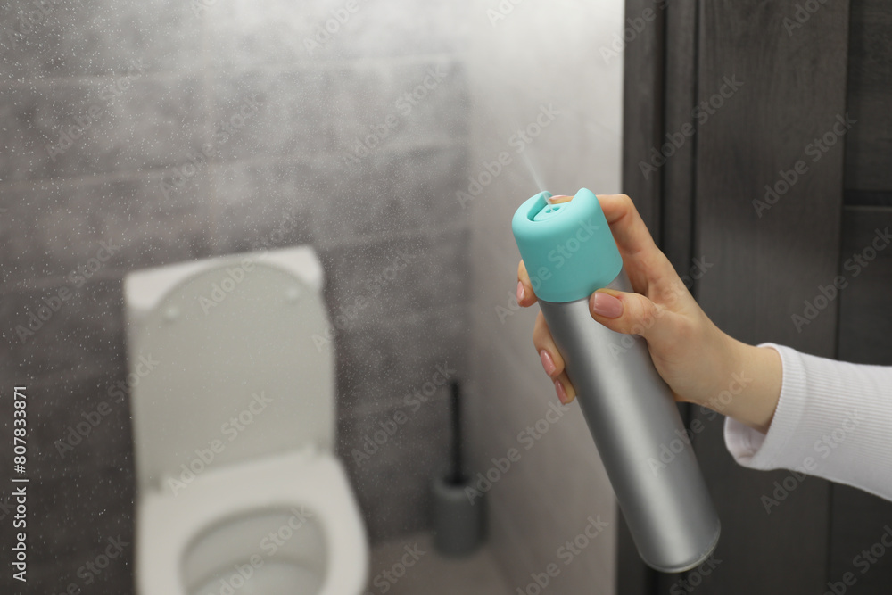 Fototapeta premium Woman spraying air freshener at home, closeup. Space for text