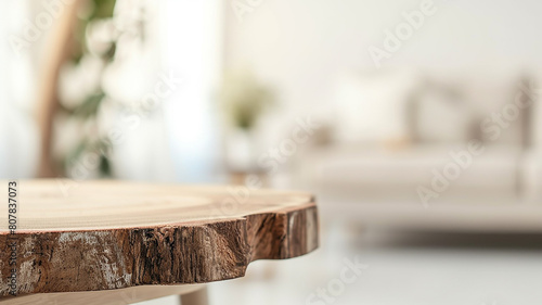 A wooden table top made of sawn wood in the interior of the room on the background of a sofa © kichigin19