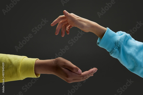 Diverse children's hands keeping safe, protecting something against dark grey background. Concept of youth, expression, beauty, emotions, gestures, art and symbolism, diversity. Ad photo
