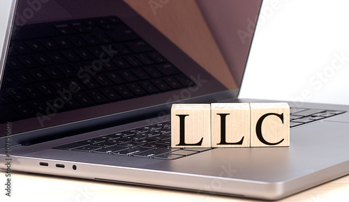 LLC word on wooden block on a laptop , business concept