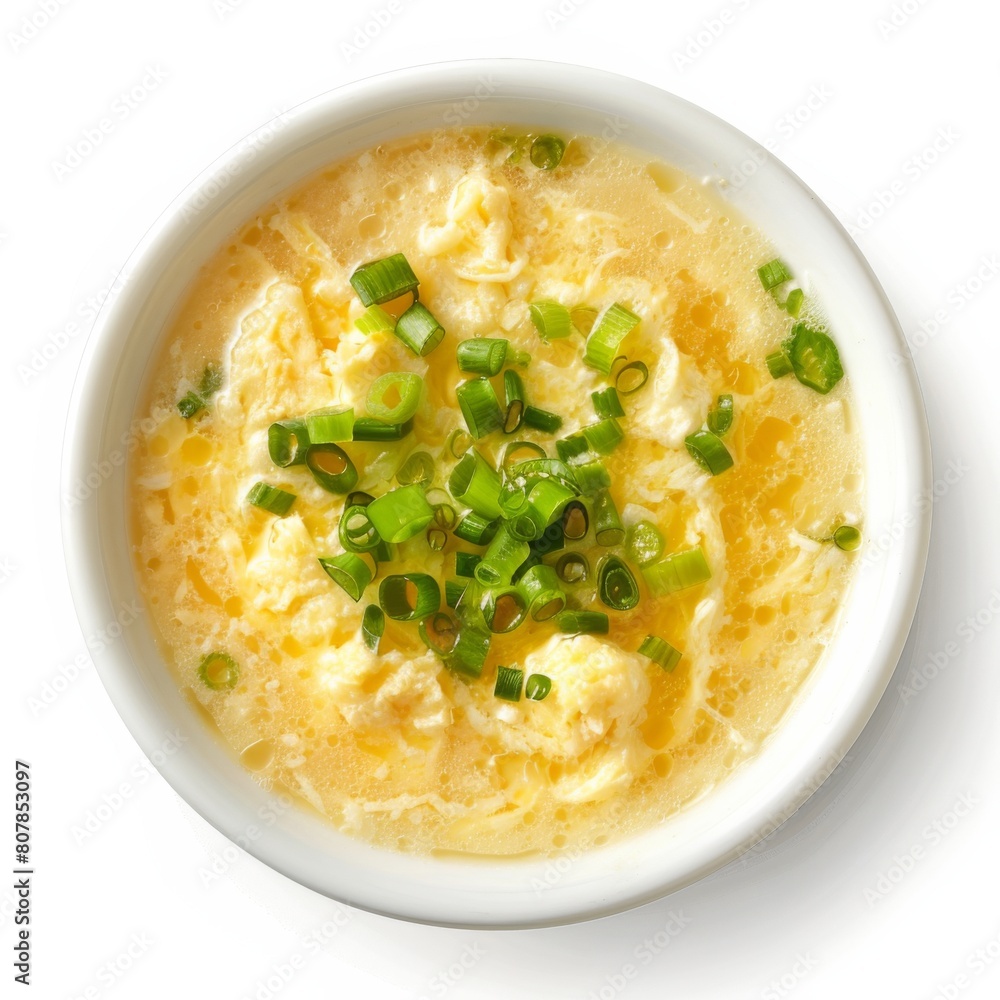 A bowl of soup topped with green onions and cheese A bowl of soup topped with green onions and cheese