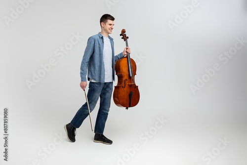 Handsome man musician playing cello on concert