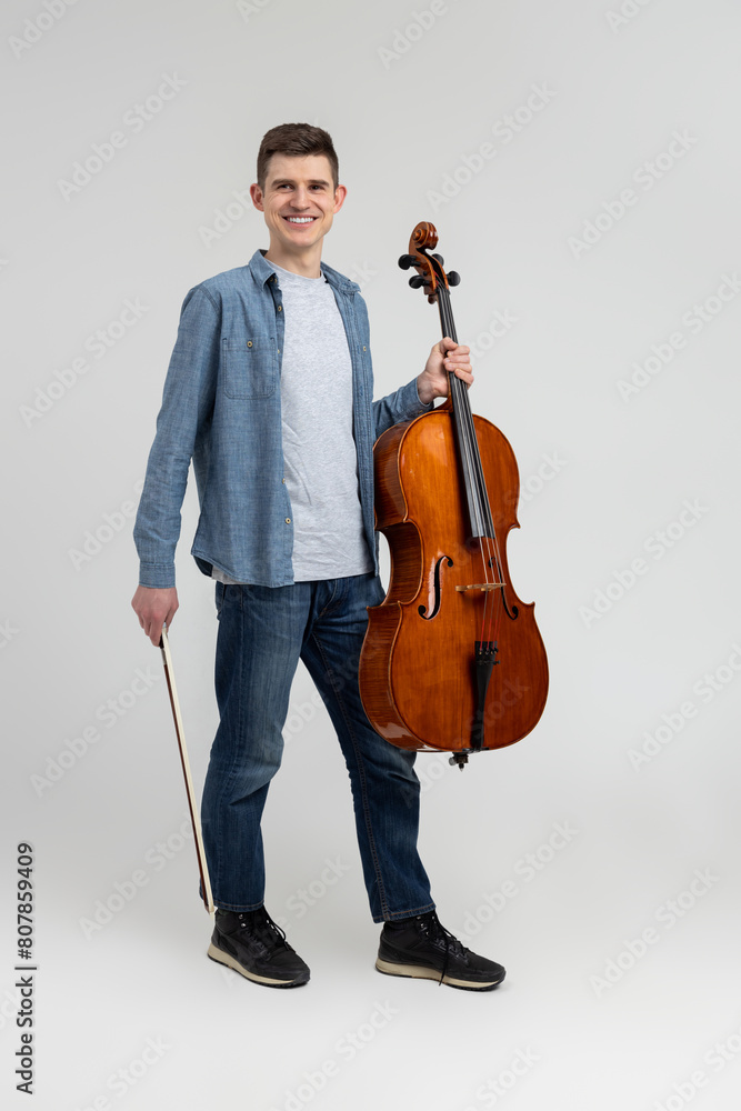 Young man wearing casual clothing playing cello