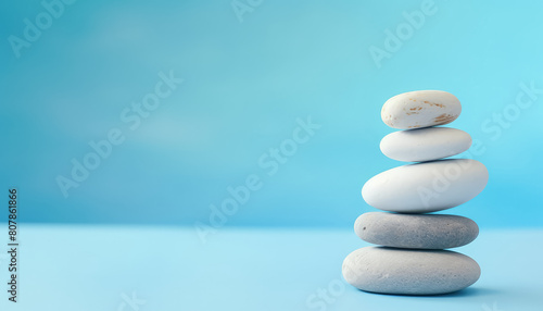 Balancing white stones on blue background