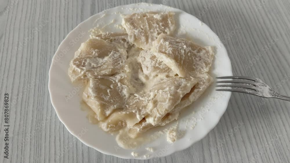 Plate of boiled dumplings with sour cream Plate of boiled dumplings with sour cream