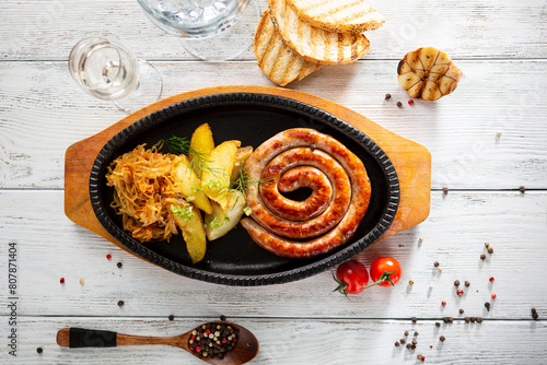 Top view grilled sausage, potato wedges and salad